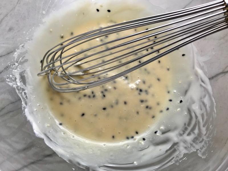 Sesame dressing mixed in bowl for Asian Lettuce Wraps. They are a fantastic way to use leftover Turkey or Chicken transforming it with new delicious flavors and textures. The turkey is stir fried with carrots, red pepper, and brussel sprouts in a flavorful ginger, garlic, & sesame sauce. It's layered in lettuce wraps with rice and a cool, crunchy purple cabbage sesame slaw. Serve with a Garlic Honey Soy Sauce....YUM!!!