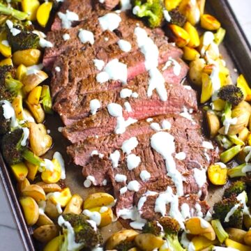 Flank Steak sliced with Potatoes & Broccoli on sheet pan with crema drizzled on top. This Flank Steak Broccoli and Potatoes dinner is an easy and delicious Sheet Pan recipe.