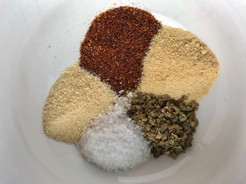 Spices in bowl for Flank Steak Rub. This Flank Steak Recipe with Potatoes & Broccoli is an easy and delicious Sheet Pan Dinner. It has a flavorful rub and a tangy, light Garlic Chive Crema!