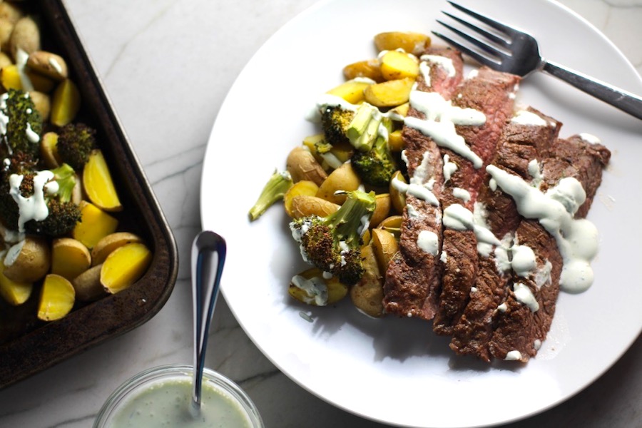 Flank Steak broccoli and potatoes on a plate with crema drizzled on top. This is an easy and delicious Sheet Pan Dinner. The homemade steak rub adds such wonderful flavor. To top this sheet pan dinner, you get this tangy, light Garlic Chive Crema! Best of all, you only need 1 pan so it's a super easy clean up. Easy and Delicious!