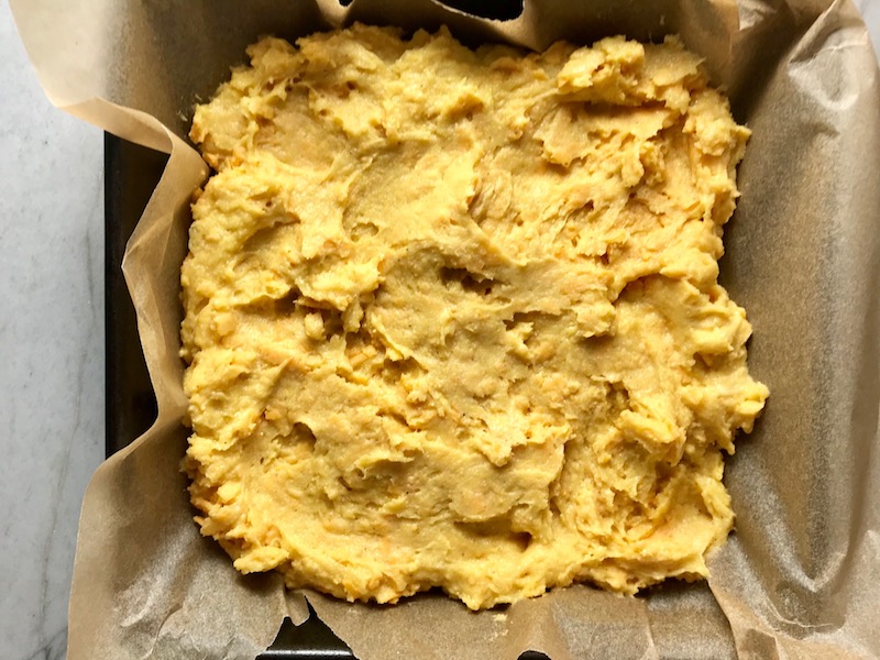 Raw batter to pan for Cheddar Honey Glazed Cornbread piece in hand with more in background. It brings the salty and sweet combo to life spectacularly - particularly when the aromas from the honey, corn, and cheddar fill your house. This Gluten Free version is moist, slight salty from the cheese, slightly sweet from the honey and cornmeal. It's the perfect holiday meal side, whether it's breakfast, brunch, or dinner.