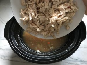 Adding shredding cooked chicken to Crock-pot for 5-Ingredient Homemade Chicken Soup. This soup is thick, creamy, and hearty. It's filled with flavorful broth, meaty shredded chicken, and sweet bursts of bright veggies. You can prepare all of the ingredients ahead and freeze them until you are ready to cook. Then, thaw, pour into the Slow Cooker, set and forget.
