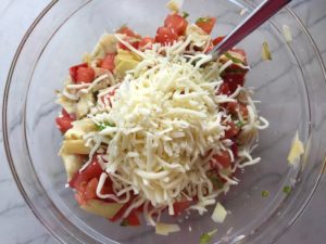 Tomato, artichoke, mozzarella in bowl for the Tomato Tart Recipe. It gives you crunch from the Quinoa crust, a burst of fresh from the tomatoes, tons of flavor from the basil and garlic, tang and meatiness from the artichoke and so much creaminess from the mozzarella and goat cheese! It's addictive and delicious!