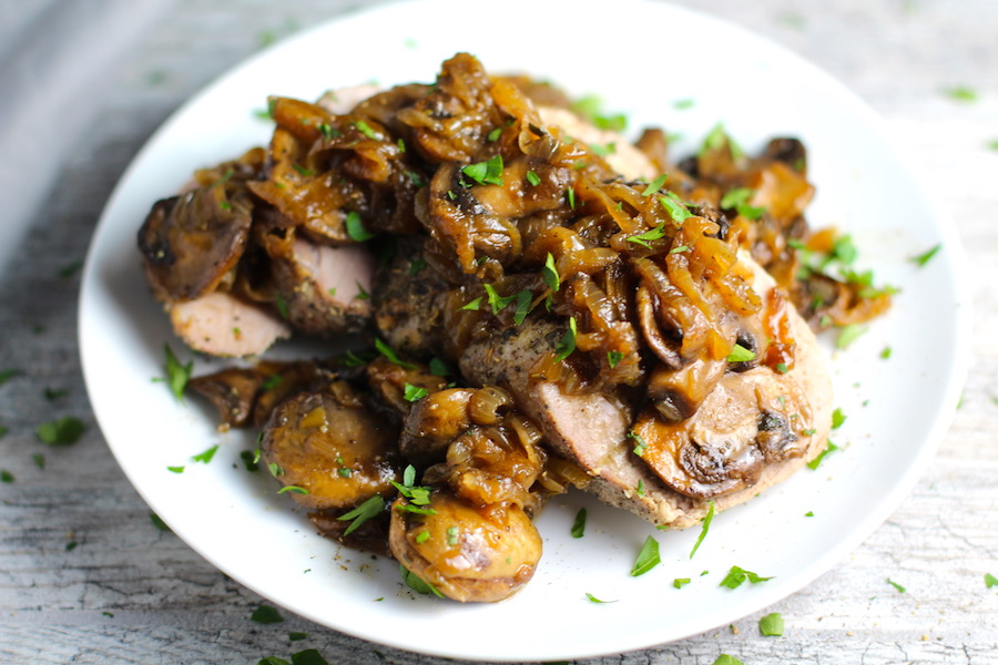 Caramelized Onions & Mushrooms on Sliced Pork Tenderloin on plate. This recipe is such a flavorful main dish! The pork tenderloin is moist and juicy and topped with Onions & Mushrooms that are sauteed low and slow with a touch of balsamic to bring out all of the natural sugars and caramelize them to perfection.