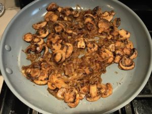 Caramelized Onions and mushroom slices in skillet for the Caramelized Onions & Mushrooms on Pork Tenderloin recipe. This is such a flavorful main dish! The pork tenderloin is moist and juicy and topped with Onions & Mushrooms that are sauteed low and slow with a touch of balsamic to bring out all of the natural sugars and caramelize them to perfection.