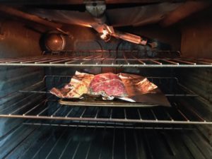 Stuffed Flank Steak in oven on center rack with broiler on. This Stuffed Flank Steak recipe is oozing with flavor! First, you get mushrooms, onions, and garlic sauteed together. Then they are mixed with fresh parsley and basil, then parmesan, and goat cheese! Roll it all up in Flank Steak and roast for an amazing dinner.