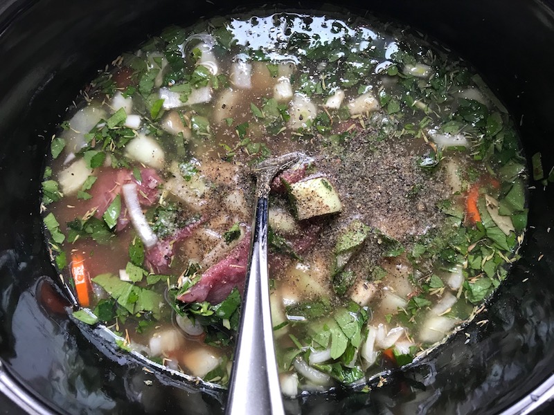 Beef, carrots, onion, broth, and other ingredients in crockpot for the Slow Cooker Beef Stew over Noodles recipe. It's comfort food full of flavor and texture with carrots, onion, garlic, thyme, beef, and more. Now, try pouring that salty, chunky, saucy goodness over noodles...yup, even more amazing! #beefstew #crockpot #slowcooker #easydinners #dinnerrecipes