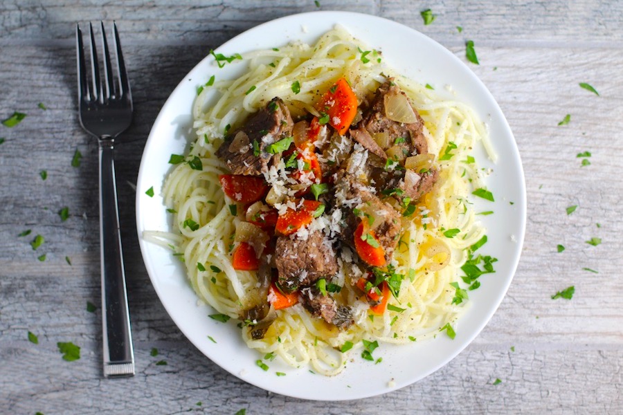 Slow Cooker Beef Stew over Noodles on a plate. This is downhome comfort food that's full of flavor and texture with carrots, onion, garlic, thyme, beef, and more. Now, try pouring that salty, chunky, saucy goodness over noodles...yup, even more amazing!#beefstew #crockpot #slowcooker #easydinners #dinnerrecipes