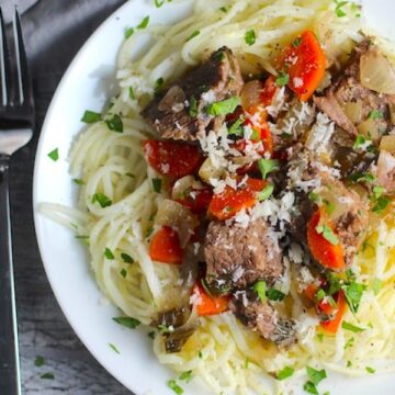 Slow Cooker Beef Stew without wine over Noodles on a plate. This is downhome comfort food that's full of flavor and texture with carrots, onion, garlic, thyme, beef, and more. Now, try pouring that salty, chunky, saucy goodness over noodles...yup, even more amazing!#beefstew #crockpot #slowcooker #easydinners #dinnerrecipes