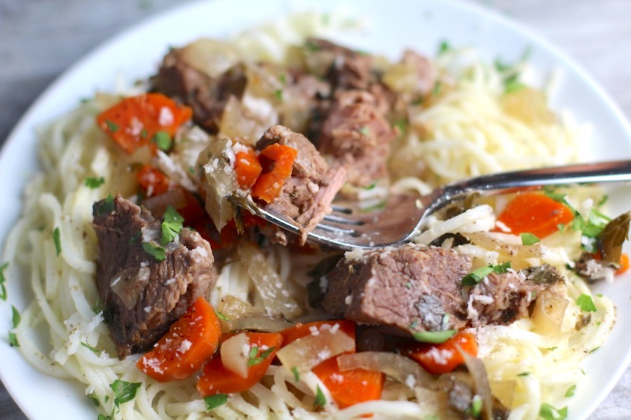 Slow Cooker Beef Stew without wine over Noodles on a plate. This is downhome comfort food that's full of flavor and texture with carrots, onion, garlic, thyme, beef, and more. Now, try pouring that salty, chunky, saucy goodness over noodles...yup, even more amazing! #beefstew #crockpot #slowcooker #easydinners #dinnerrecipes