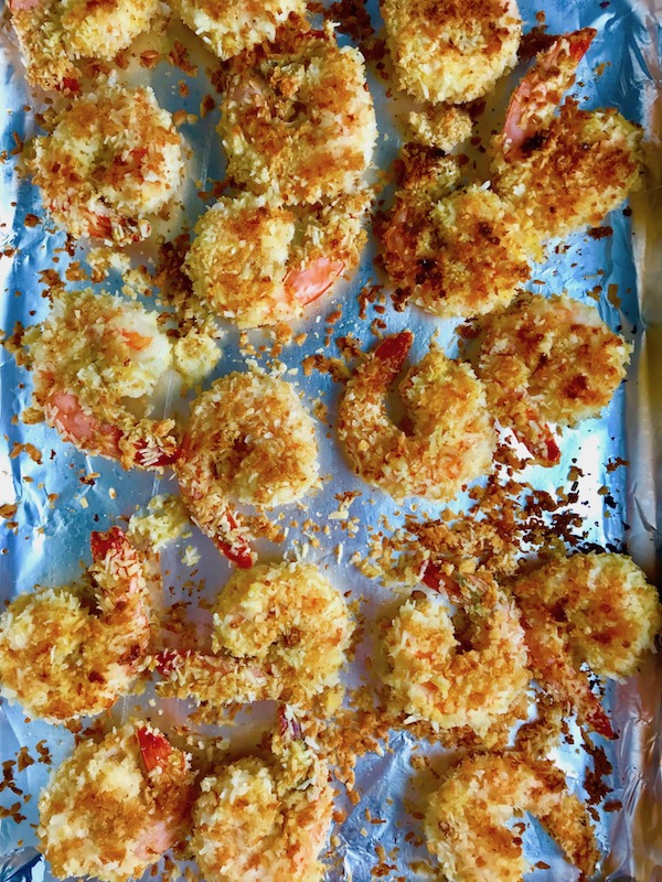 Baked Coconut Shrimp on pan. Crunchy and utterly irresistible, this 30-Minute Baked Coconut Shrimp recipe is one that you have got to try! They are baked, not fried, so they are EASY to cook and HEALTHIER for you too!