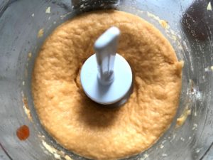 Blended Chickpeas and Sriracha in food processor for Magical Sriracha Hummus. This recipe is seriously the easiest hummus you will ever make and it's perfect for snacking or adding to a meal. The chickpeas have so much flavor and the Sriracha gives it a kick that is totally addictive!