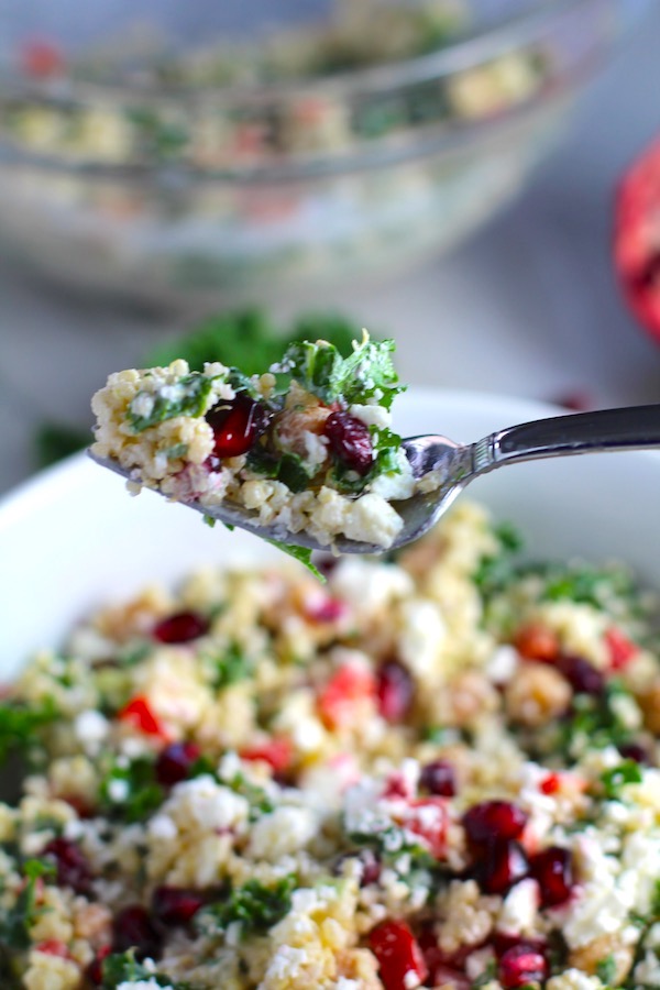 Fork with bite of Quinoa & Kale Salad with Roasted Chickpeas, Pomegranate,Feta, and Creamy Lemon Dressing. #glutenfree #lunch #dinner #healthyrecipes #healthyfood #salads #quinoa #kale
