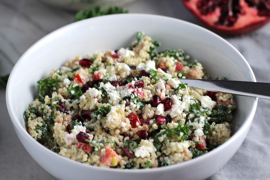 Close up of bowl of Quinoa & Kale Salad with Roasted Chickpeas, Pomegranate, Feta, red pepper, and Creamy Lemon Dressing. #glutenfree #lunch #dinner #healthyrecipes #healthyfood #salads #quinoa #kale