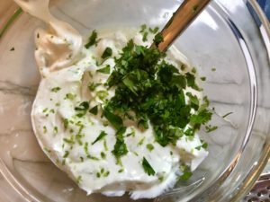 Sour cream, cilantro, and lime in bowl for Slow Cooker Pork Tacos with with Pickled Onions, Shredded Cheese, and Cilantro Lime Crema drizzled on top! It's such an easy dinner since the pork cooks in the slow cooker to be perfectly seasoned and fall apart tender. #tacos #easydinner #glutenfree #dinner #mexican #pork