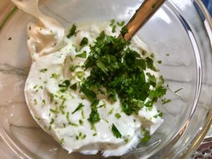 Sour cream, cilantro, and lime in bowl for Slow Cooker Pork Tacos with with Pickled Onions, Shredded Cheese, and Cilantro Lime Crema drizzled on top! It's such an easy dinner since the pork cooks in the slow cooker to be perfectly seasoned and fall apart tender. #tacos #easydinner #glutenfree #dinner #mexican #pork