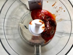 Chipotle peppers in adobo and ketchup in food processor for Chipotle Meatloaf. Cheddar Cheese gives depth and more flavor. It's incredibly easy, incredibly moist, and incredibly delicious! A family dinner favorite! #meatloaf #mexican #easydinner #familydinner #dinner #easyrecipes #beef