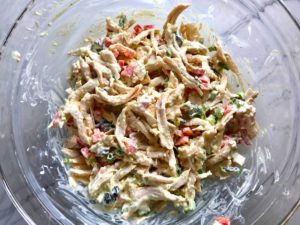 Curry Chicken Salad mixed in bowl. It has so many fantastic flavors and textures! The chicken breast is simply roasted and mixed with a creamy sweet and savory curry dressing. Red pepper gives you a fresh crunch, scallion gives a savory bite, and raisins give a burst of sweet. #chicken #chickenrecipes #chickensalad #currychicken #mealprep #lunch #healthyrecipes