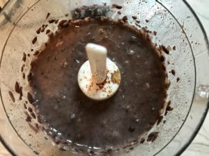 Black Beans, garlic, seasonings in food processor for Huevos Tostadas! They are similar to Huevos Rancheros but are a pick up and eat with your hands version! They have crispy corn tortillas topped with creamy mashed black beans, a salty fried egg, smoky tomato sauce, cheese, and scallions! #huevosrancheros #eggs #brunch #mexicanrecipes #vegetarian #meatlessrecipes #glutenfree