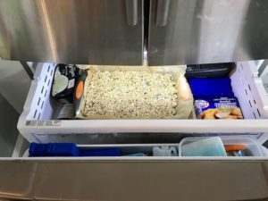 No Bake Energy Bites in a sheet pan in freezer to set. These Easy Nut-Free, No-Bake Energy Bites with Chocolate Chips are magnificent! They are sweet, chewy, crunchy, & healthy. Only minutes to make & no Baking! Breakfast, snack, or dessert. #energybars #granolabars #snackrecipes #healthyfood #healthyrecipes #healthysnacks #healthybreakfast #healthydessert