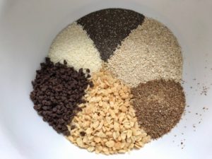 All dry ingredients (rice cereal, flaxseed, oats, chia seeds, coconut, chocolate chips) in bowl for No Bake Energy Bites. These Easy Nut-Free, No-Bake Energy Bites with Chocolate Chips are magnificent! They are sweet, chewy, crunchy, & healthy. Only minutes to make & no Baking! Breakfast, snack, or dessert. #energybars #granolabars #snackrecipes #healthyfood #healthyrecipes #healthysnacks #healthybreakfast #healthydessert