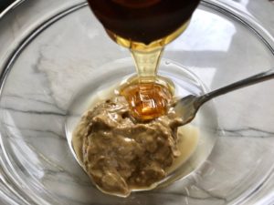 Pouring honey into Sun Butter in bowl with fork for No Bake Energy Bites. These Easy Nut-Free, No-Bake Energy Bites with Chocolate Chips are magnificent! They are sweet, chewy, crunchy, & healthy. Only minutes to make & no Baking! Breakfast, snack, or dessert. #energybars #granolabars #snackrecipes #healthyfood #healthyrecipes #healthysnacks #healthybreakfast #healthydessert