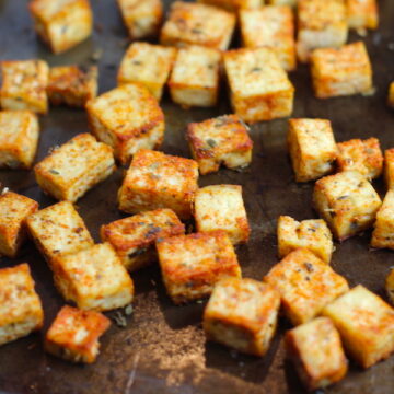 Savory Baked Tofu Bites on pan. These are seasoned and toasted for the perfect addition to any salad, pasta, rice, or soup!   They get a roasted, almost nutty flavor with a salty and smoky seasoned crust with a chewy bite.  Super easy to make, low carb and great source of protein!  #croutons #salad #tofu #tofurecipes #vegetarian #plantbased #paleo