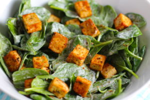 Savory Baked Tofu Bites on a spinach salad.