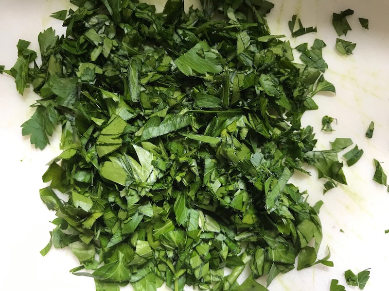 Chopped parsley for Cauliflower Cordon Bleu Bake recipe. It layers in nutty and salty Gruyere Cheese, with a creamy Vegetable broth based sauce with garlic and parsley. Then the ham and cauliflower are folded into all of this goodness and it's baked in the oven until it all becomes one knock-your-socks-off dish! #cauliflower #lowcarb #glutenfree #casserole #onepot #familydinner #mealprep #easydinner #dinner #healthydinner #healthyfood #healthyrecipes