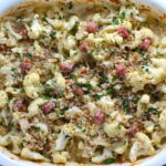 Gluten Free Cauliflower Cheese and Ham Bake with parsley and breadcrumb topping. It layers in nutty and salty Gruyere Cheese, with a creamy Vegetable broth based sauce with garlic and parsley.  Then the ham and cauliflower are folded into all of this goodness and it's baked in the oven until it all becomes one knock-your-socks-off dish! #cauliflower #lowcarb #glutenfree #casserole #onepot #familydinner #mealprep #easydinner #dinner #healthydinner #healthyfood #healthyrecipes