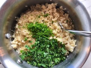 Chopped cilantro and lime zest on quinoa in pot for Cilantro Lime Quinoa. It's fluffy, nutty, citrusy, salty, and the perfect accompaniment for any protein or vegetable!  With just a few simple ingredients, you can make this fantastic healthier alternative to rice. #quinoa #quinoarecipes #sides #healthyfood