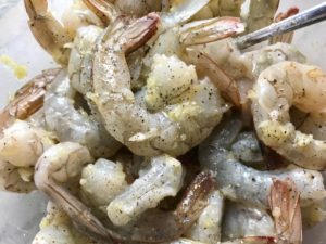 Raw shrimp mixed with minced garlic, oil, salt, pepper for Garlic and Lime Shrimp with Tzatziki Sauce. The Shrimp is simply sauteed with minced garlic, olive oil, and lemon for big bold flavors. The Tzatziki Sauce is bright and cool with creamy yogurt with fresh cucumber, lime, garlic, and scallion. #shrimp #easydinner #dinner #seafoodrecipes #shrimprecipes