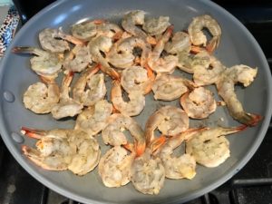 Shrimp cooking in skillet for Garlic and Lime Shrimp with Tzatziki Sauce. The Shrimp is simply sauteed with minced garlic, olive oil, and lemon for big bold flavors. The Tzatziki Sauce is bright and cool with creamy yogurt with fresh cucumber, lime, garlic, and scallion. #shrimp #easydinner #dinner #seafoodrecipes #shrimprecipes