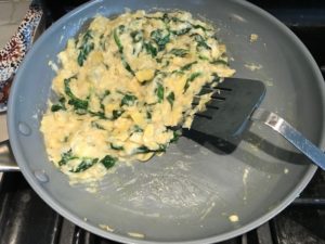 Spinach artichoke stuffing in pan for Spinach Artichoke Stuffed Zucchini. Each fantastic bite gives you creamy artichoke, nutty cheesy Parmesan, spinach, and zucchini. Prepare entirely ahead, then bake 20 minutes and enjoy! #vegetarian #zucchini #stuffedzuchini #spinach #artichoke #springrecipes #healthyfood #healthydinner #healthyrecipes #glutenfree