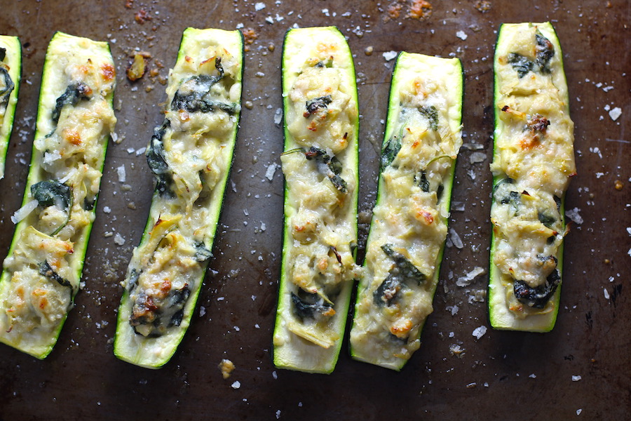 Artichoke Spinach Stuffed Zucchini Recipe on a pan. Each fantastic bite gives you creamy artichoke, nutty cheesy Parmesan, spinach, and zucchini. Prepare entirely ahead, then bake 20 minutes and enjoy! #vegetarian #zucchini #stuffedzuchini #spinach #artichoke #springrecipes #healthyfood #healthydinner #healthyrecipes #glutenfree