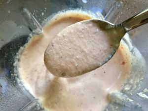 Spoon with Cauliflower cream sauce over blender for Meatballs in Cauliflower Dill Cream Sauce. #meatballs #swedishmeatballs #familydinner #easydinner #dinner #healthydinner