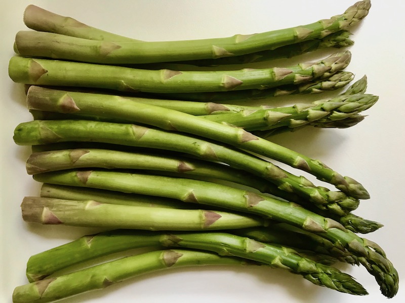 Raw Asparagus on counter for Lemon Dill Sauce Chicken and Asparagus has chicken in a light and creamy sauce flavored with garlic, lemon and fresh dill. It's loaded with fresh asparagus. #springrecipes #dinner #easydinner #healthydinner #lemon #asparagus #chicken #glutenfree #easyrecipes