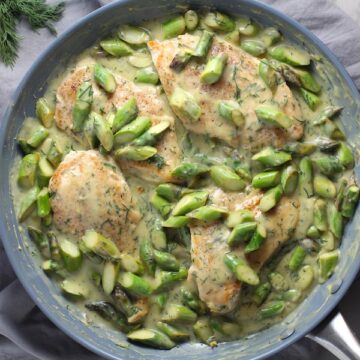 Cooked Lemon Dill Sauce Chicken and Asparagus in pan on stove. It has chicken in a light and creamy sauce flavored with garlic, lemon and fresh dill. It's loaded with fresh asparagus. #springrecipes #dinner #easydinner #healthydinner #lemon #asparagus #chicken #glutenfree #easyrecipes