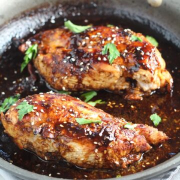 Sesame Sweet Chili Chicken cooked in skillet with cilantro leaves. It is slightly sweet, tangy, savory, nutty, with a touch of heat. You can prepare it days ahead, it takes just minutes to prepare, minutes to cook, and everyone will love it!! #chicken #marinades #easydinner #easychicken #chickenrecipes #easysauces #healthydinner #healthyfood #healthyrecipes