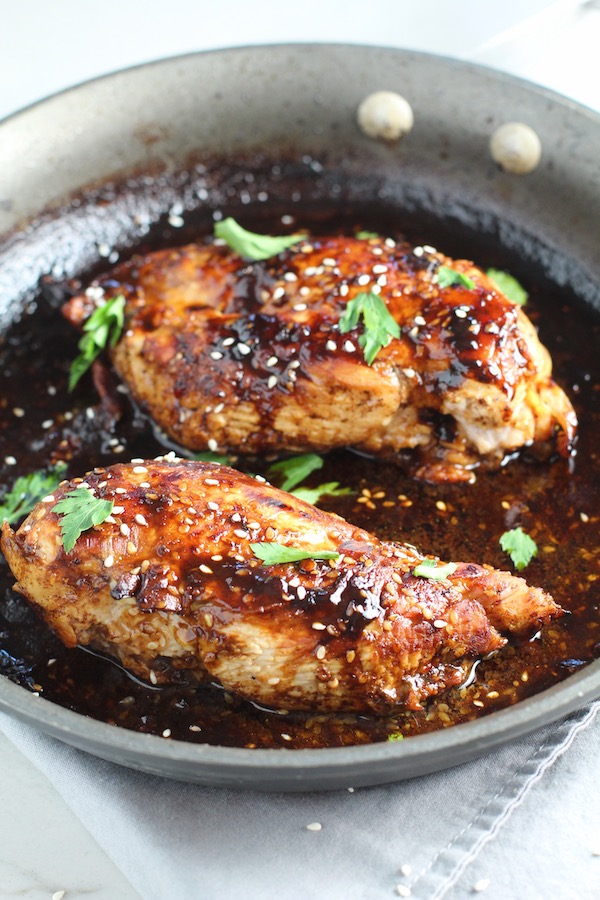Sesame Sweet Chili Chicken cooked in skillet with cilantro leaves. It is slightly sweet, tangy, savory, nutty, with a touch of heat. You can prepare it days ahead, it takes just minutes to prepare, minutes to cook, and everyone will love it!! #chicken #marinades #easydinner #easychicken #chickenrecipes #easysauces #healthydinner #healthyfood #healthyrecipes