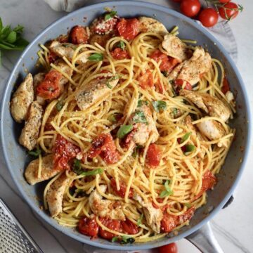 Chicken and Cherry Tomato Pasta with basil and parmesan in a skillet. It's easy and so delicious!