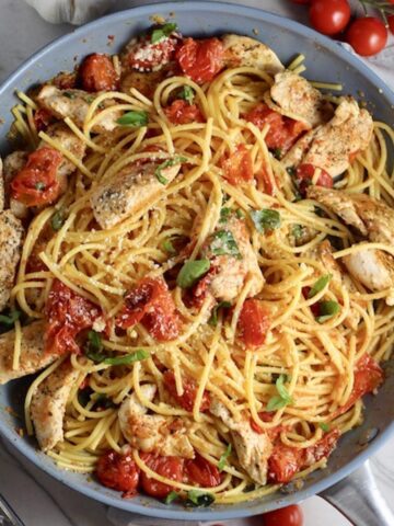 Chicken and Cherry Tomato Pasta with basil and parmesan in a skillet. It's easy and so delicious!
