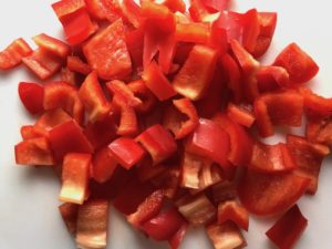 Chopped red pepper for Skillet Eggs in Spicy Tomato Pepper Sauce with Manchego Cheese. With a smoky, spicy, thick, and luscious red pepper tomato sauce. #eggs #huevosrancheros #tomatosauce #easydinner #brunch #shakshuka