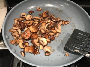 Mushrooms in skillet for Olive & Pancetta Flatbread with mozzarella, mushrooms, and fresh basil. #flatbread #pizza #olives #tapenade #mediterranean #easydinner #dinner