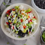 Black Bean Taco Bowl with rice, smoky black beans, avocado, salty Cotija cheese, sour cream, fresh tomato, and bright cilantro. This Black Bean Taco Bowl Bar lets everyone fills their bowl with any of the toppings they want! Perfect for kids. #tacos #tacobowls #healthyfood #dinner #healthydinner #familydinner #kidsdinner #blackbeans #vegetarian