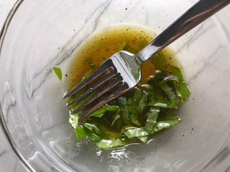 Basil Vinaigrette in bowl with fork for Grilled Halloumi Cheese & Tomato Salad. It's insanely delicious! Grilled Halloumi has a strong savory and salty flavor that is slightly creamy and incredibly addictive. Paired with my simple Tomato and Basil salad, each bite is simply heaven. #halloumi #appetizers #salads #grilling #summerfood