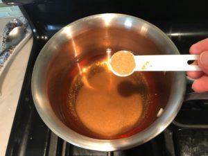 Adding Cumin to vinegar in a pot for Pickled Onions in a bowl soaking. They are tart, tangy, sweet, and savory. They go on just about anything and are so unbelievably delicious, they can make a shoe taste good! Best part, you can make a ton of them ahead!