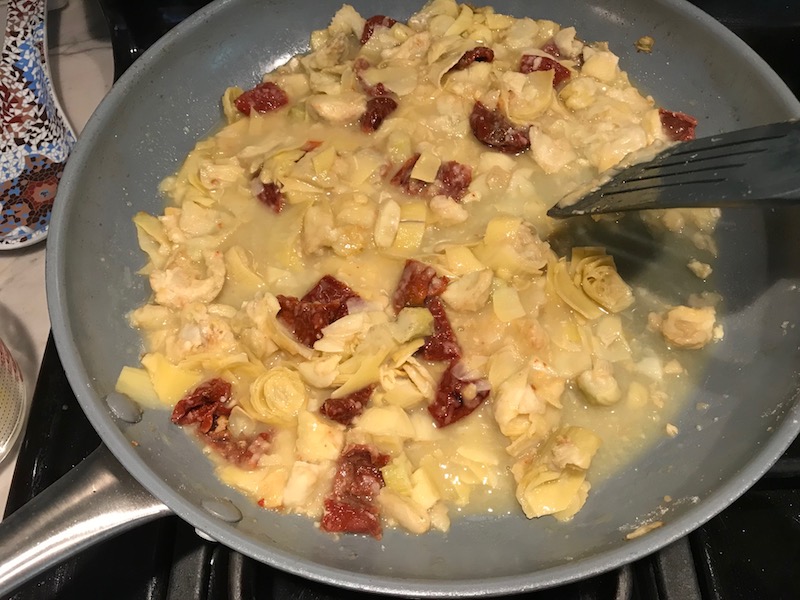 Artichoke and sun dried tomatoes sauce in pan for Skillet Artichoke Chicken with sun dried tomatoes, basil, garlic, in cream sauce. #skilletchicken #skilletdinner #chicken #easydinner #familydinner #italian #tuscanchicken