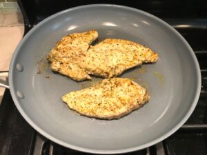 Mediterranean Chicken Cooking in a skillet. This Mediterranean Marinade is only a few ingredients, can be made ahead, and is delicious!