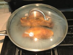 Marinated Mexican Chicken cooking in skillet with lid on. This marinade is an easy, make-ahead, and delicious recipe! The chicken is infused with so much smokey, savory flavors from the fresh garlic, chili powder, and cumin. #marinade #chicken #easydinners